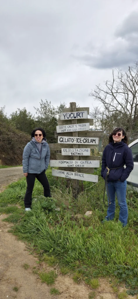 Matorina und Rong an einem Wegweiser, die Haare fliegen durch den Wind durch die Gegend.