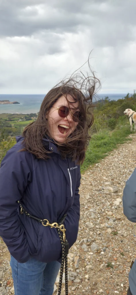 Matorina mit der Küste im Hintergrund. Ihre Haar fliegen durch die Luft.