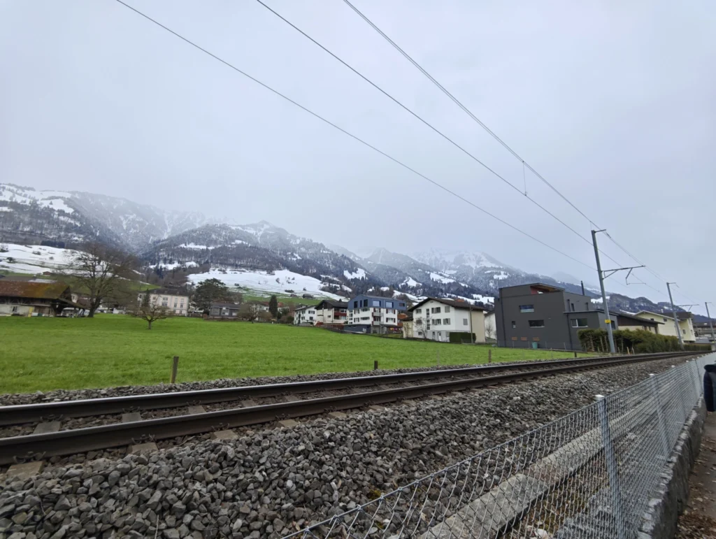 Blick über die Schienen der örtlichen S-Bahn in die Berge